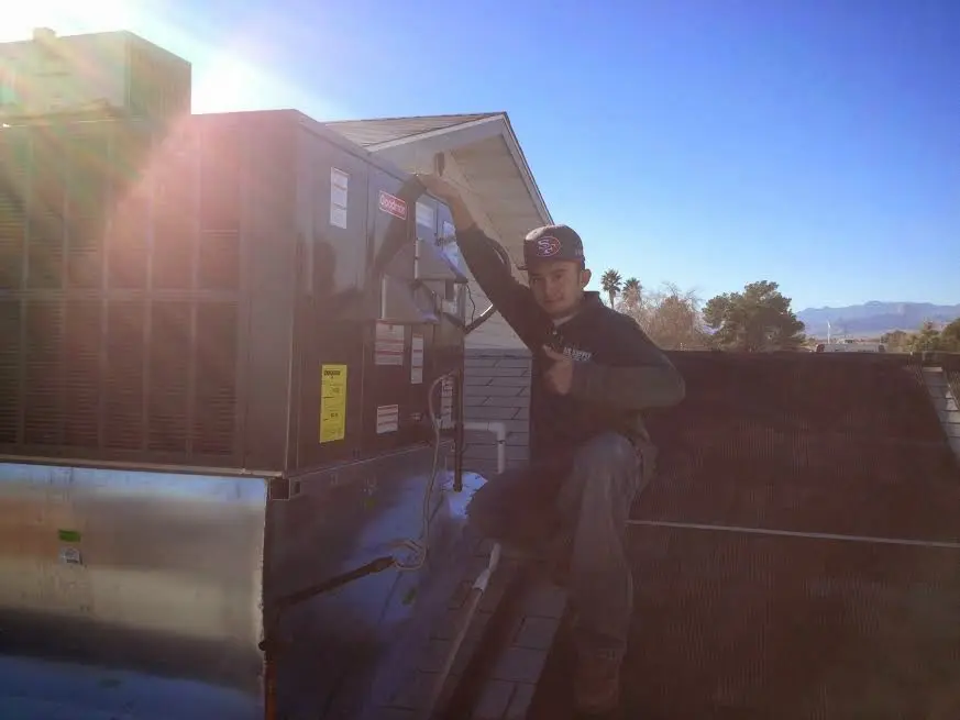 HVAC technician performing Air Duct Cleaning on a rooftop unit in Hudson